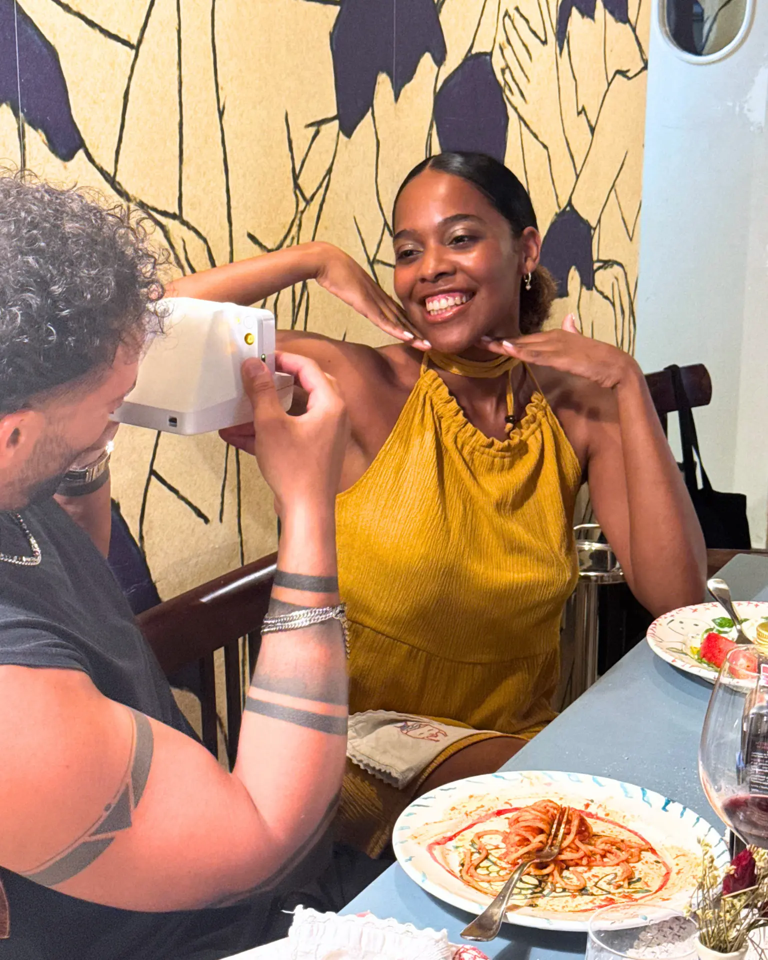 Amici sorridenti a tavola con piatti e vino bianco a Capri